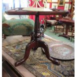 A George III style wine table the pinched cornered top on turned and reeded column with carved