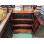 A Bevan Funnell Georgian style mahogany serpentine front wall hanging four tier shelf with three