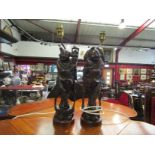A pair of carved wooden Chinese figures with white metal inlay,