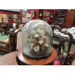 Two Victorian glass domes covering dried flower displays,