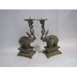 A pair of ornate Eastern white metal candlesticks as elephants on footed stands, approx.