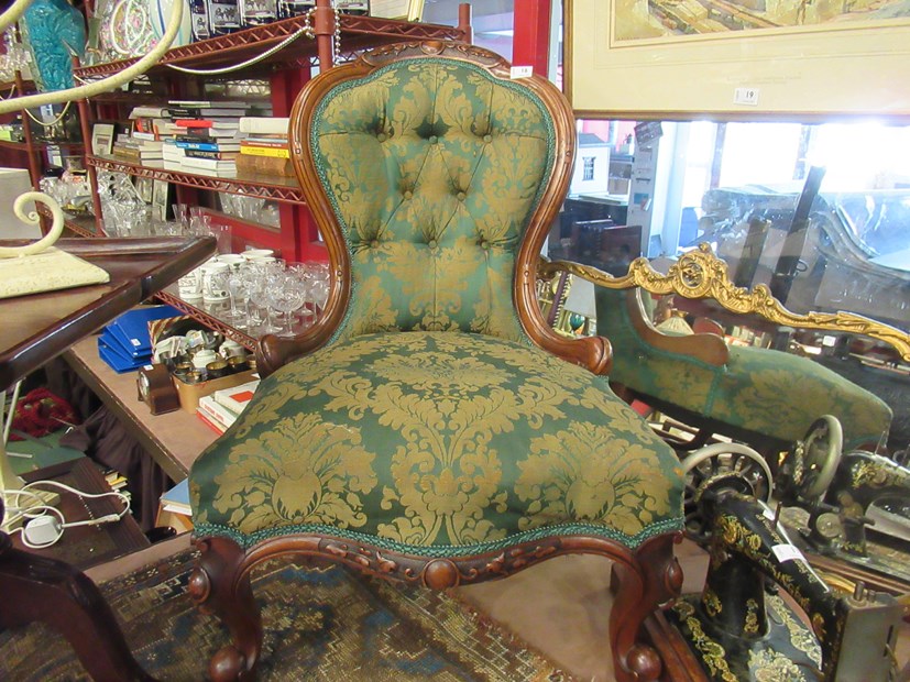 A mid Victorian carved walnut button-back armchair,