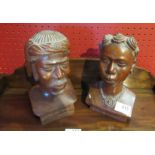 A pair of carved hardwood busts depicting a male and female.