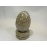 A grey stone egg and mount (2 pieces)