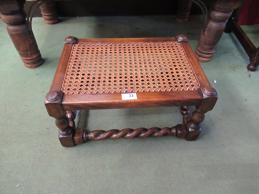 An Edwardian bergère stool, the caned seat on turned legs joined by barley-twist stretchers,