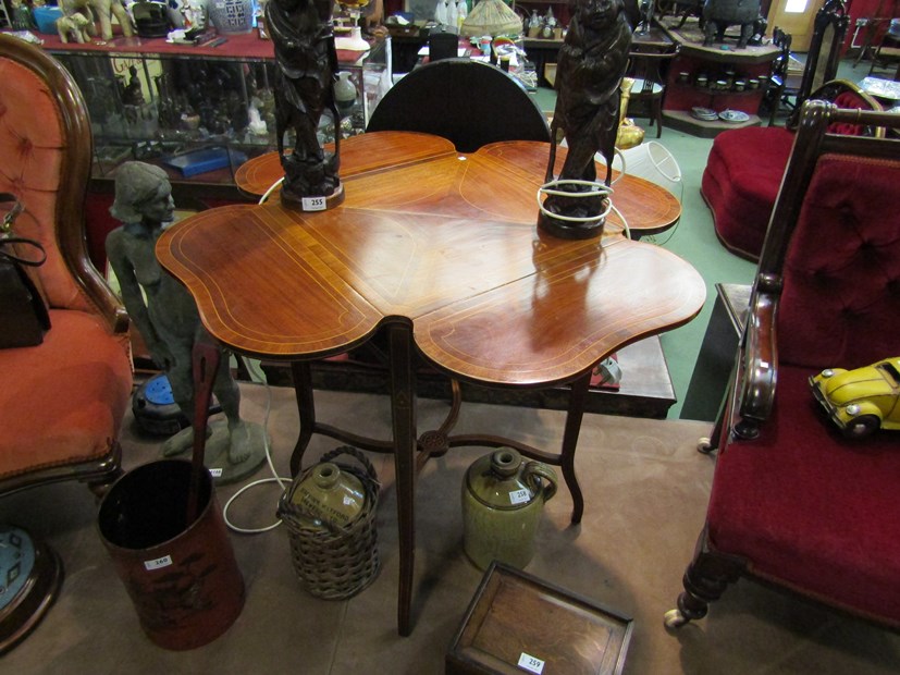 An Edwardian mahogany occasional table with shaped drop-flaps, decorative line inlay,