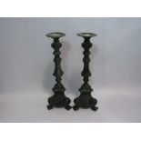 A pair of ornate metal candlesticks,