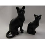 Two figures of black cats