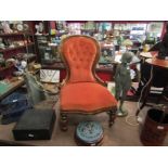 A mahogany open buttonback armchair with serpentine seat on turned legs,