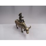 A brass oriental figure riding a water buffalo,