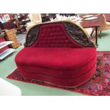 A 19th Century walnut carved frame conversation chair upholstered in Burgundy velvet reputedly from
