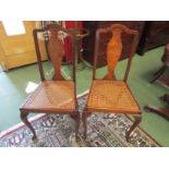 A pair of Edwardian walnut cane seat chairs,