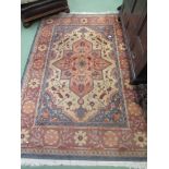 A beige, coral and blue ground rug with floral design,