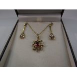 An 18ct gold pendant set with rubies and diamonds and a matching pair of earrings, 6.