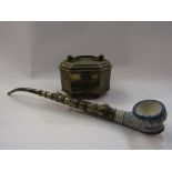 A brass hinged box with handle on ball feet and an opium pipe