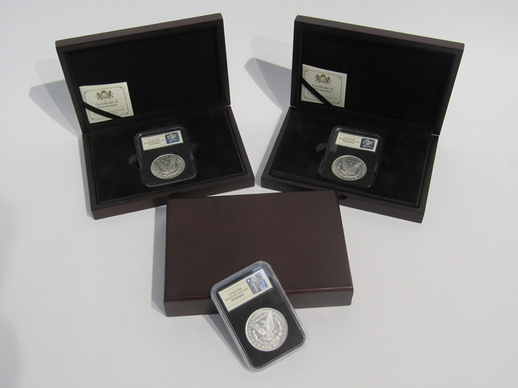 Three US silver Morgan dollars, Philadelphia, cased and boxed,