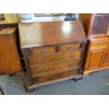 A mahogany bureau, reeded columns, two over three drawer base, carved bracket feet,