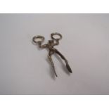 A set of silver nips in the form of a jester,