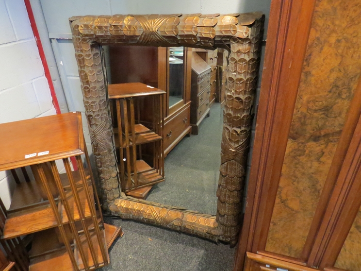 A large gilt metal feature mirror with bevelled glass,