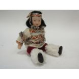 An Articulated china doll in native American costume,