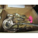 A box containing silver plated flatware including a ladle, serving spoons,