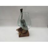 A modern driftwood ornament with moulded glass vase,