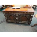 A 17th Century and later oak coffer, the plank top over a parquetry frieze to two arched panels,