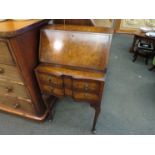 A Queen Anne style bureau with drop-flap over two drawers on pad feet,