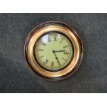 A modern circular wall clock with Roman numerated dial,