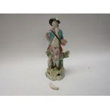 An early 19th Century porcelain figure of a gentleman in tricorn hat with dog (a/f).