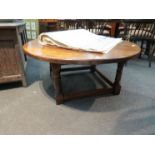 An oak circular coffee table on stretcher base,