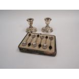 A pair of silver squat form candlesticks together with a cased set of 6 silver coffee bean spoons