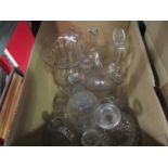 A box containing mostly glass decanters