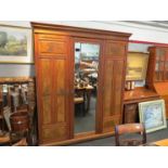 A Victorian walnut wardrobe, central mirrored door flanked by two further burr wood panelled doors.