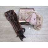 A small vintage suitcase containing a fur stole and a 1940's fox fur evening cape