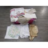 A box containing various table linens including damask Victorian cotton examples and beige