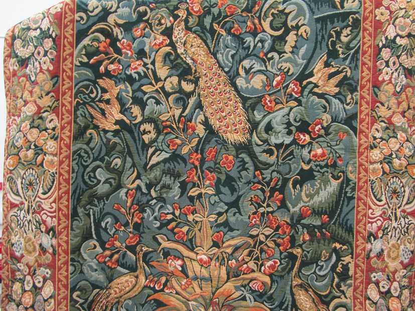 A modern machine woven wall hanging tapestry depicting peacocks in a stylized naturalistic setting,