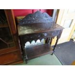 A 19th Century carved oak side table with green man design to drawer on pot cupboard under tier,