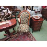 A carved bedroom chair with foliate detailing and Art Nouveau style upholstery on castors