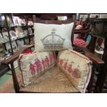 Three cushions including male and females in period dress and an embroidered crown