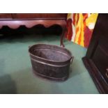 An embossed oval coal bucket with ring handles and foliate detail,
