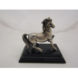A silver horse on a plinth.