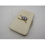 An Edwardian ivory card case with enamel blue and white jockey cap,