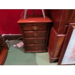 A pair of panelled oak bedside chests each having four graduated drawers over bun feet,