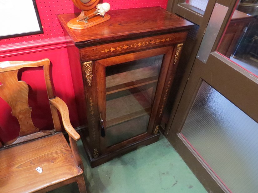 Circa 1840 an inlaid rosewood pier cabinet with brass ormolu mounts the single glazed door with key