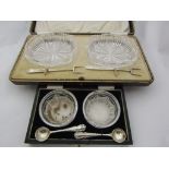 A pair of crystal glass salts and silver spoons,
