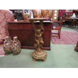 A gilt torchère stand as a cherub, scroll base and paw feet,