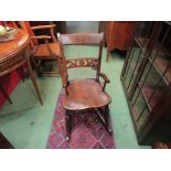 Circa 1860 an East Anglian elm knife back child's rocking chair with fretwork cross splat on ring