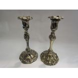 A pair of silver plated classical candlesticks with scrolled foliage relief, 25.