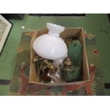 A box containing oil lamp chimney and shades and a selection of brassware,
